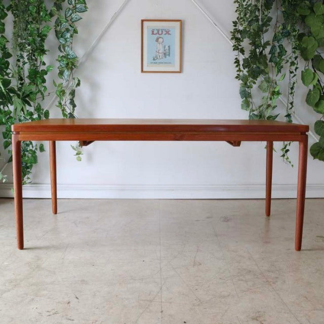 Mid-century vintage teak dining table by Johannes Andersen with sleek rectangular top, slender tapered legs, and natural.
