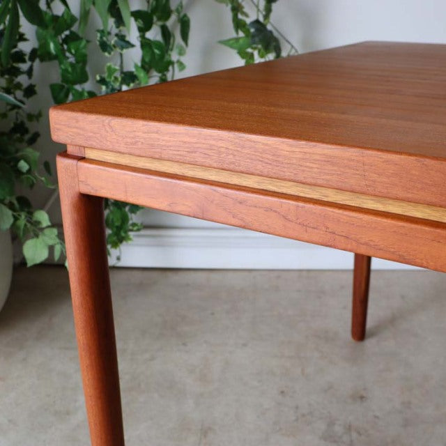 Mid-century vintage teak dining table by Johannes Andersen with rectangular top, smooth wood grain, and slender tapered.