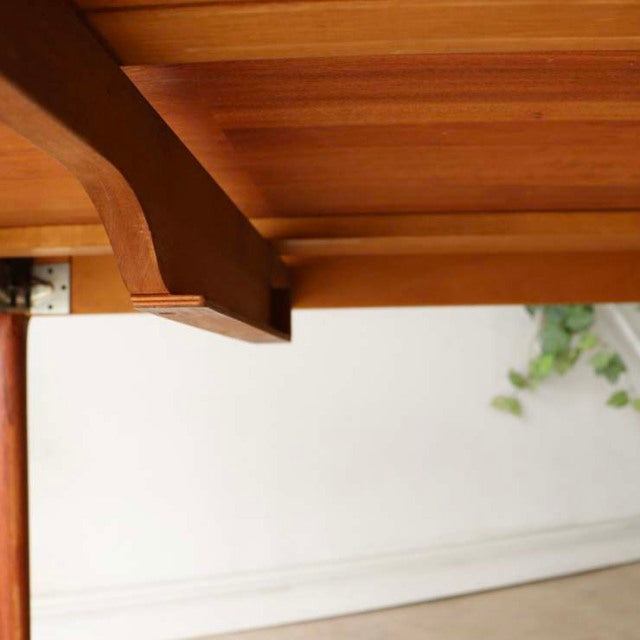 Mid-century vintage teak dining table leg and underside detail with smooth grain, Scandinavian Danish design.