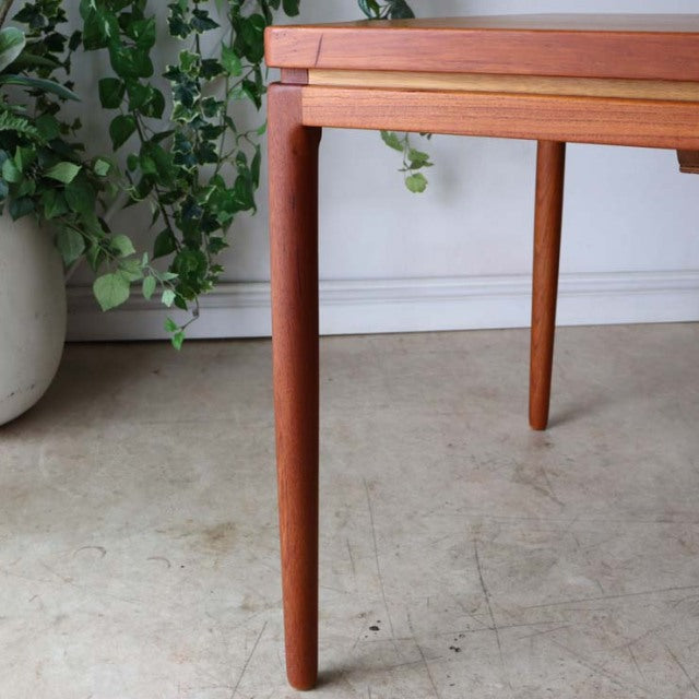 Mid-century vintage teak dining table by Johannes Andersen, rectangular with rounded tapered legs and smooth wood grain,.