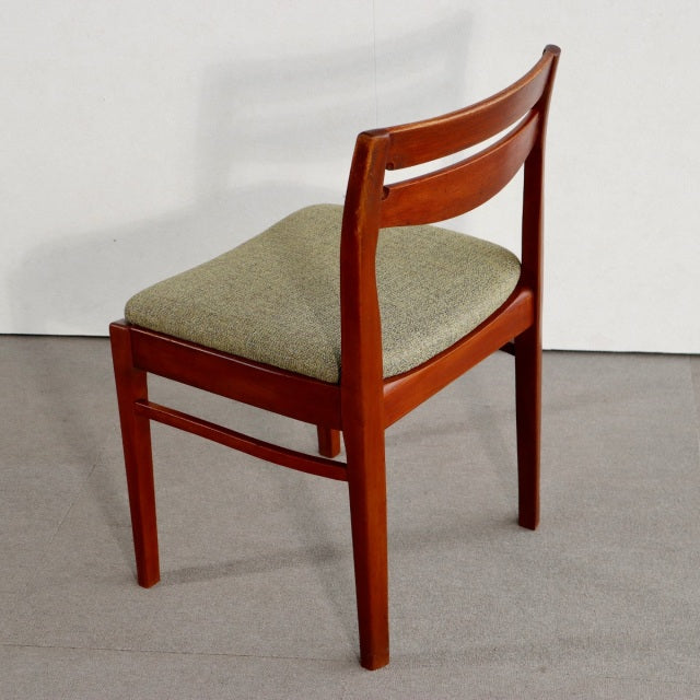 Mid-century British vintage teak dining chair by NATHAN, beige upholstered seat, curved backrest with wood grain visible.