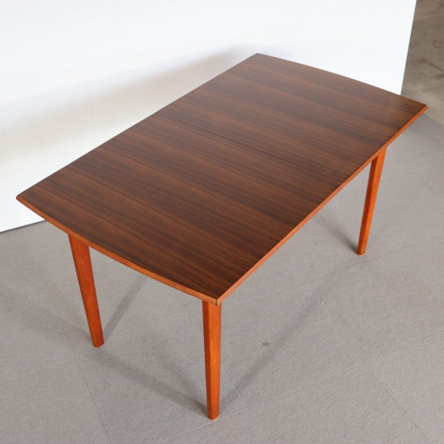 Mid-century British teak dining table with rectangular top, rich wood grain, and tapered legs from Denmark vintage collection.