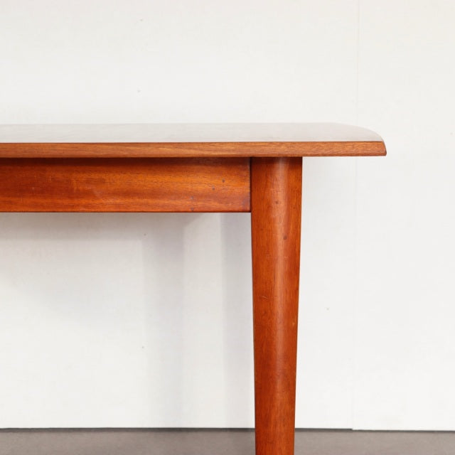 Mid-century British teak dining table with rectangular top, smooth wood grain, and tapered legs from Denmark vintage style.