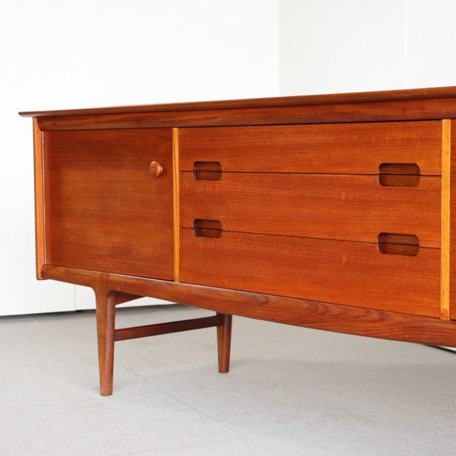 Mid-century vintage teak sideboard by YOUNGER with rich wood grain, tapered legs, sliding door, and three drawers, British.