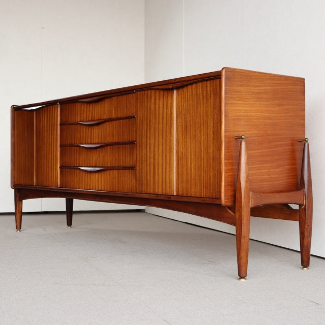 Vintage British mid-century teak sideboard by Elliotts of Newbury with sculpted wood grain, curved drawer handles, and.