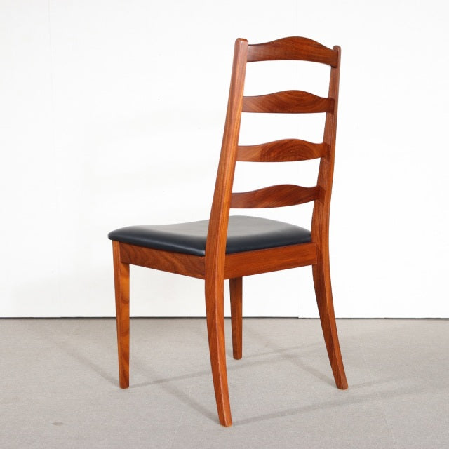 Mid-century British G-Plan dining chair in vintage teak with curved ladder back and black upholstered seat.