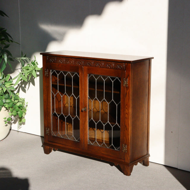 Vintage British mid-century teak cabinet by Jaycee, ornate carved details, glass-paneled doors with geometric patterns,.