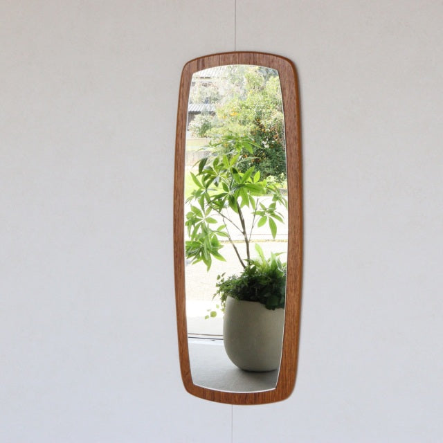 Vintage mid-century British teak wall mirror with elongated rectangular shape and rounded corners, showing rich wood grain.