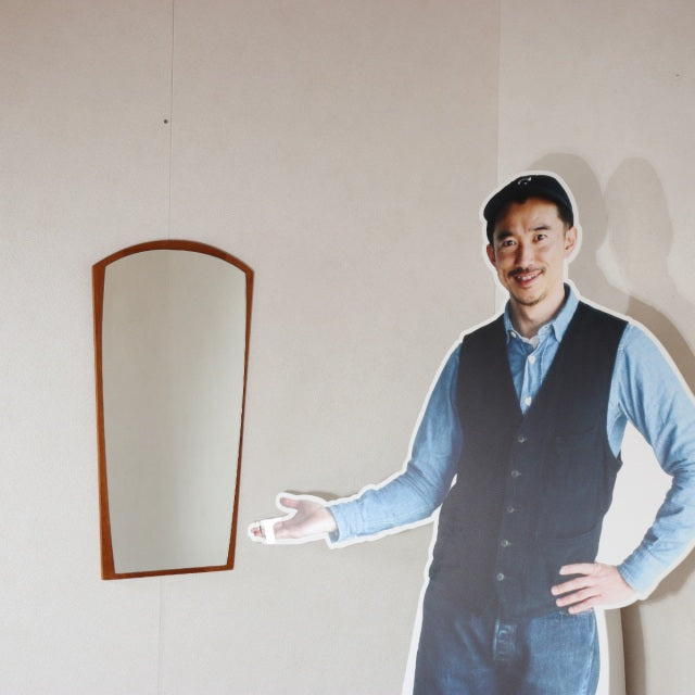 Mid-century vintage teak wall mirror from Denmark with an arched top and sleek wood grain frame.