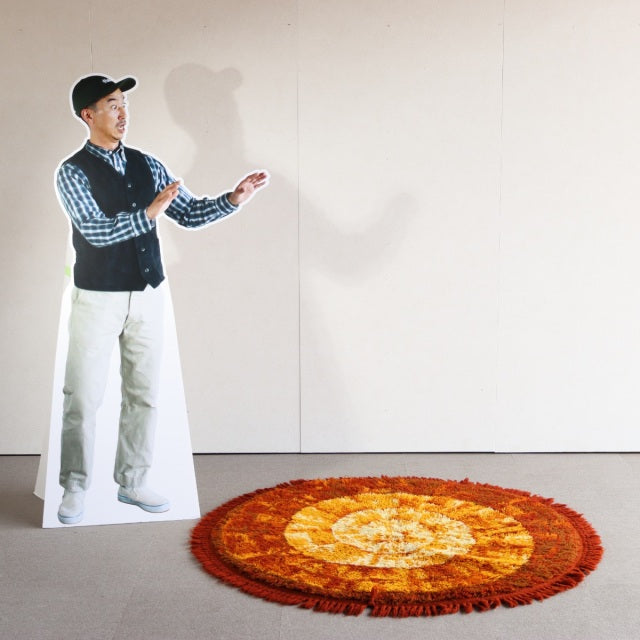 Round vintage teak rug with warm orange and brown tones, fuzzy textured concentric design, mid-century British and Danish.