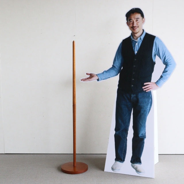 Slim mid-century British vintage teak floor lamp with smooth wood grain and round base, minimalistic design.