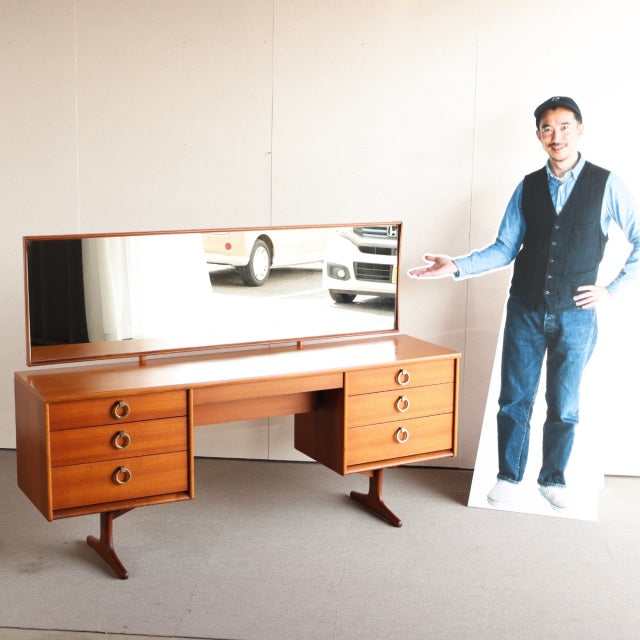 Vintage teak British mid-century dresser with six rounded drawers, sleek tapered legs, and wide rectangular mirror from.