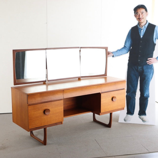 Mid-century vintage teak dresser with Danish style, British influence, rounded drawer handles, and tripod legs.