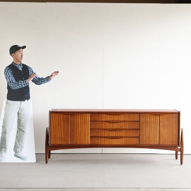Vintage British mid-century teak sideboard by Elliotts of Newbury with curved slatted doors and tapered legs.