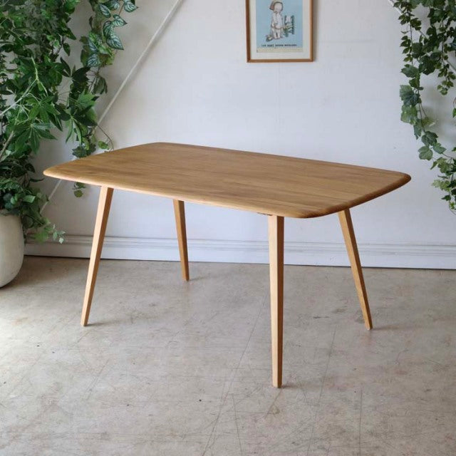Mid-century British vintage Ercol dining table in teak with rounded rectangular top and slender tapered legs, showcasing.