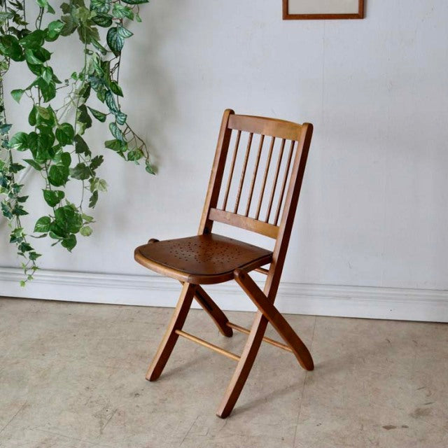 Vintage British mid-century teak folding chair with slatted backrest and curved seat, Danish design influence.