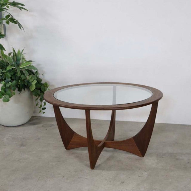 Vintage mid-century British teak coffee table by G-PLAN with round glass top and sculptural legs.