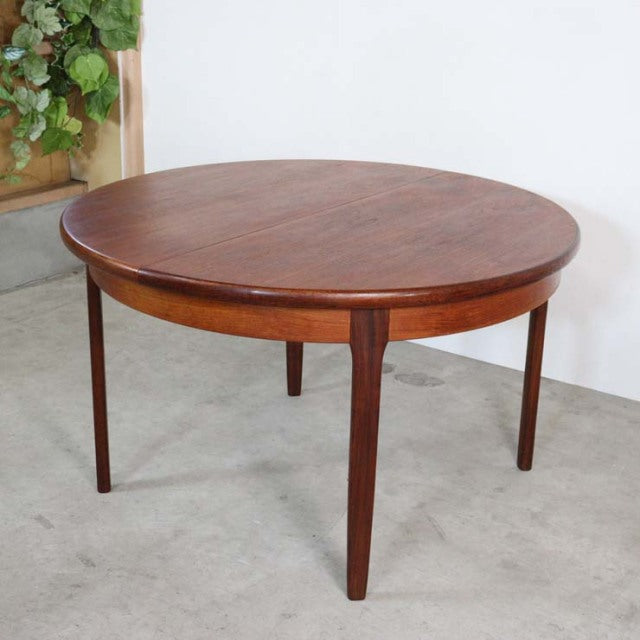 Vintage British mid-century teak dining table with oval top, clean wood grain, and tapered legs from Elliotts of Newbury.