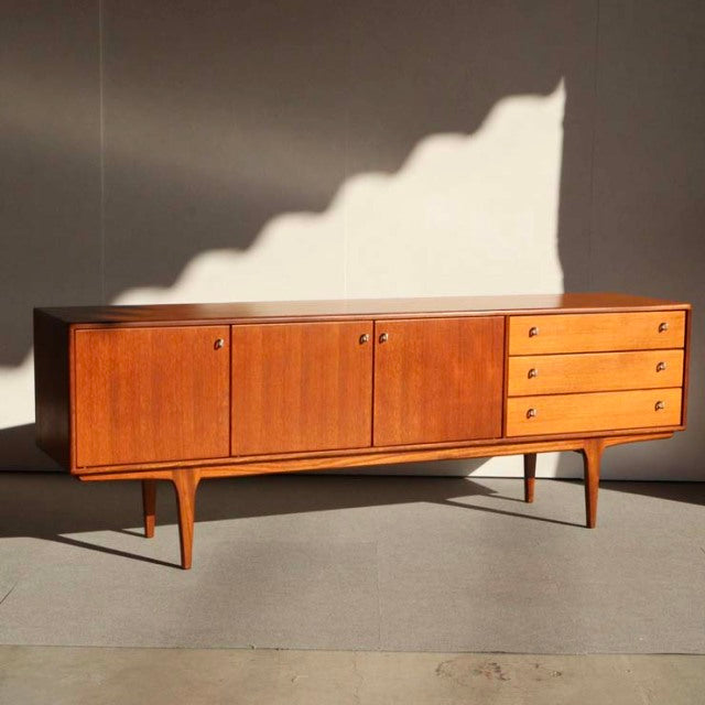 Vintage mid-century teak sideboard by Younger, British-Danish style, smooth wood grain, tapered legs, three drawers and two.
