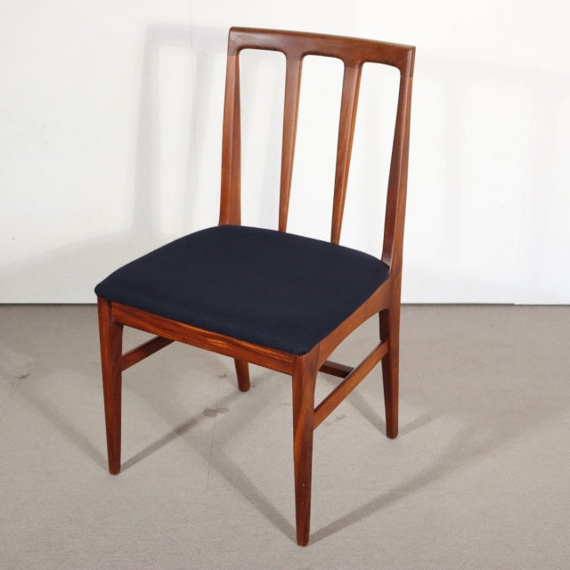 Vintage teak dining chair with sleek British mid-century design, angled legs, and navy upholstered seat.