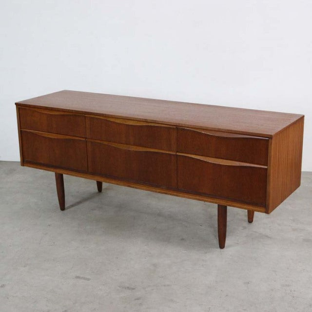 Vintage British mid-century teak sideboard by Austinsuite with curved drawer fronts and tapered legs.