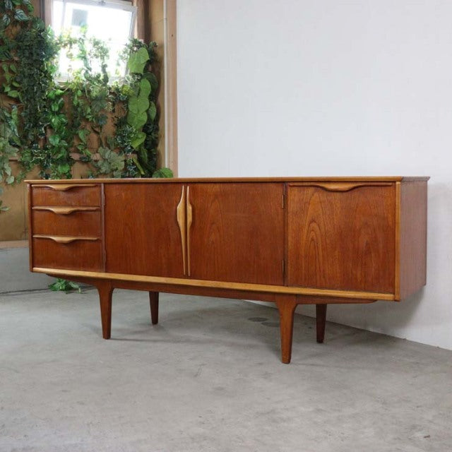Mid-century vintage teak Jentique sideboard with British design, curved legs, and elegant wood grain detailing.