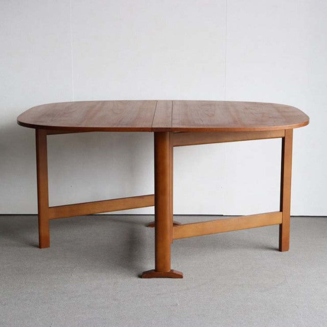 Mid-century vintage teak folding dining table with rounded edges and sturdy British or Danish craftsmanship, showcasing warm .