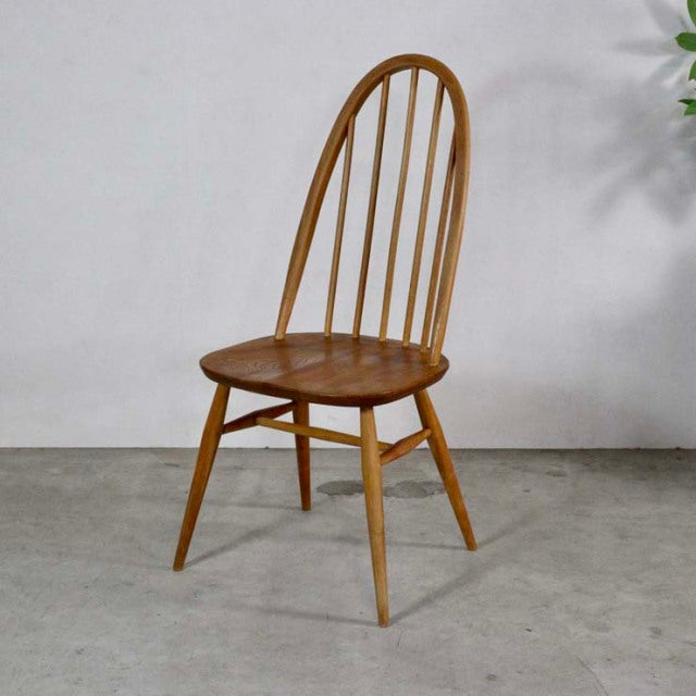 Vintage British mid-century Ercol Quaker chair in warm teak with spindle back and tapered legs.