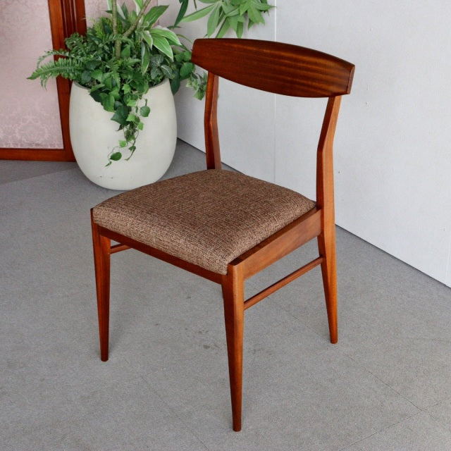 Mid-century British McIntosh dining chair in vintage teak with curved backrest and brown fabric seat cushion, tapered legs.
