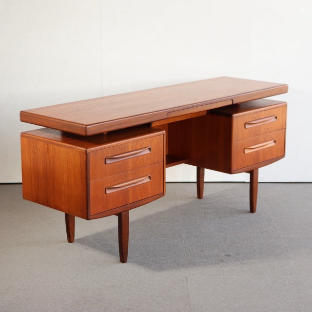 Vintage British mid-century teak G-PLAN desk with smooth wood grain, two drawers on each side, and tapered legs from Denmark.