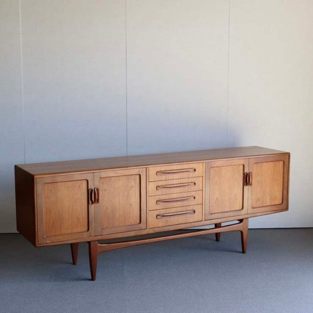 Mid-century British vintage teak G-PLAN Fresco sideboard with rich wood grain, four doors, five central drawers, and tapered .