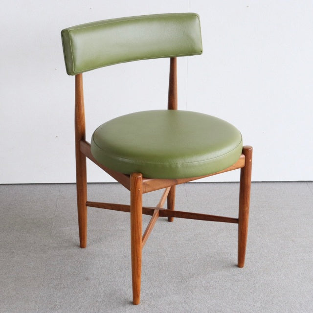 Vintage British mid-century teak dining chair with round olive-green leather seat and curved backrest.