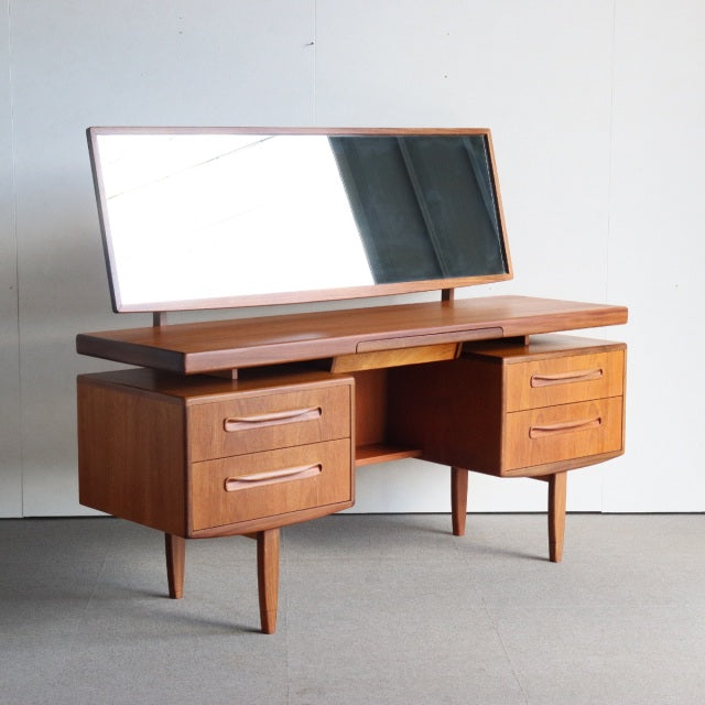 Vintage teak G-Plan mid-century British dresser with sleek wood grain, curved drawer handles, tapered legs, and a wide.