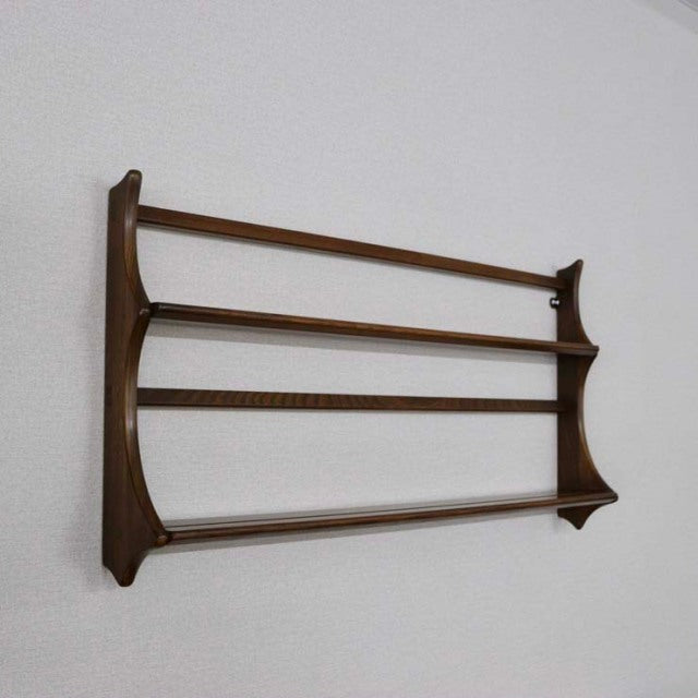 Vintage British mid-century teak Ercol wall-mounted plate rack with smooth curved sides and three horizontal slats.