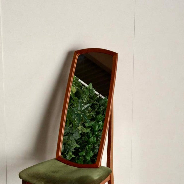 Vintage British mid-century teak standing mirror with rich wood grain and slender legs, Danish design influence.