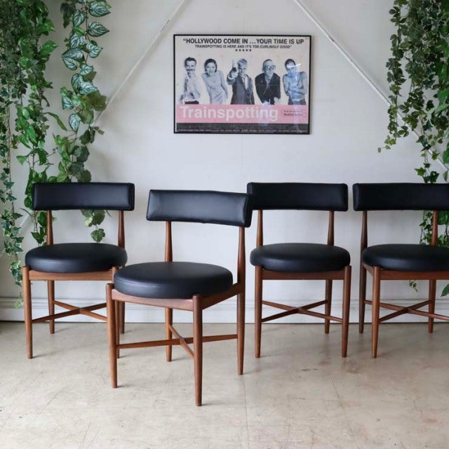 Set of four vintage G-Plan mid-century dining chairs in teak with black leather seats and curved backrests, showcasing rich.
