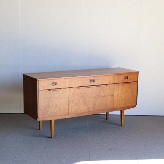 Vintage mid-century teak sideboard with clean lines, tapered legs, and British-Denmark design influence.