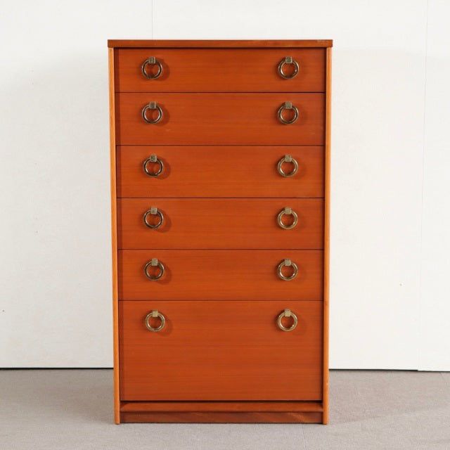 Mid-century British vintage teak chest with six drawers, brass ring pulls, and clean lines, showcasing warm wood grain and.