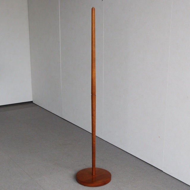 Vintage British mid-century floor lamp crafted from warm teak wood with straight cylindrical post and round base, showcasing .