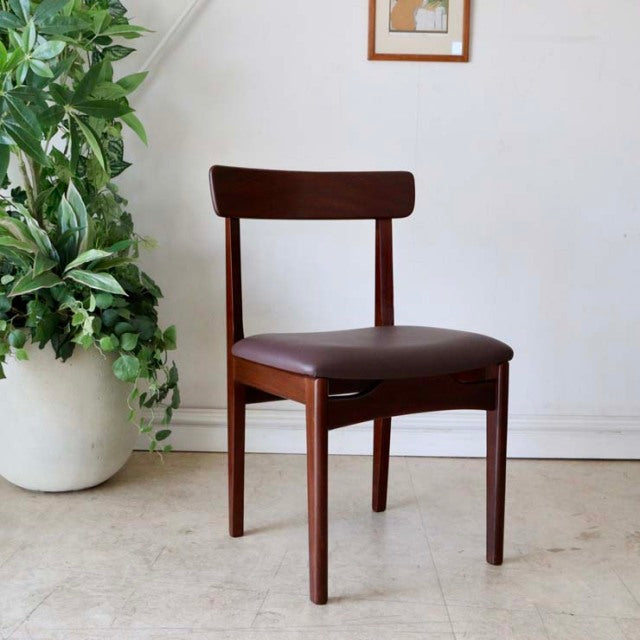 Mid-century British vintage teak dining chair with curved backrest, tapered legs, and smooth polished wood grain.