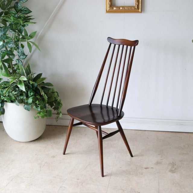 Mid-century British vintage Ercol Goldsmith dining chair in rich teak with a curved spindle back and tapered legs.