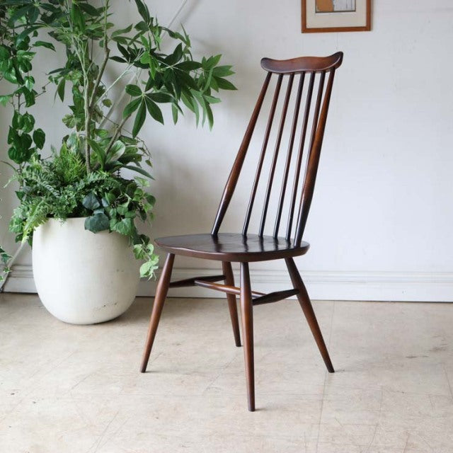 Mid-century British vintage Ercol dining chair in rich teak with slender spindled backrest and tapered legs.