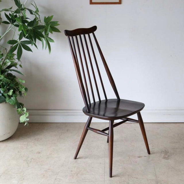 British mid-century vintage Ercol Goldsmith dining chair in dark teak with slender spindle back and tapered legs.