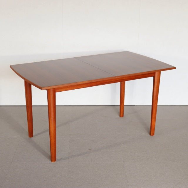 Vintage British mid-century teak dining table with clean rectangular top and tapered legs, showcasing smooth wood grain and.