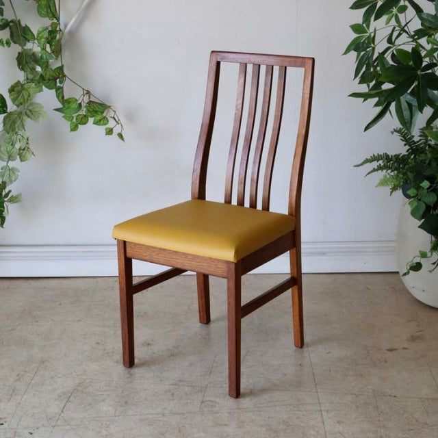 Mid-century British vintage teak dining chair with vertical slat back and mustard yellow upholstered seat.