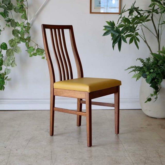 Mid-century British vintage teak dining chair with curved slat back and yellow upholstered seat.