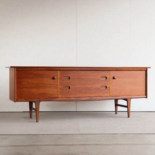 Vintage teak sideboard by Younger, British mid-century design with smooth wood grain, tapered legs, and integrated handles.