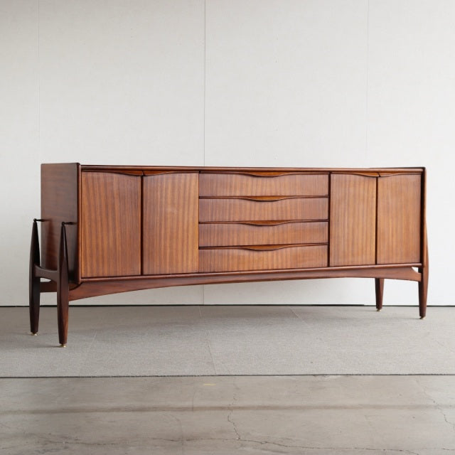 Mid-century British teak sideboard by Elliotts of Newbury with vertical grain doors, four central drawers, and tapered legs.