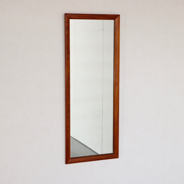 Vintage mid-century British teak wall mirror in rectangular frame with warm wood grain.