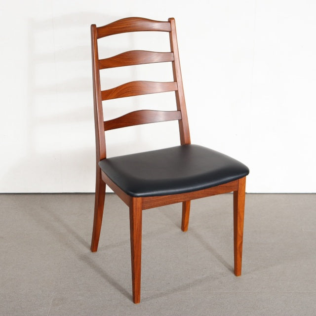 Vintage British G-Plan mid-century dining chair in teak with curved slat back and black upholstered seat.